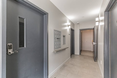 a corridor with a door to a hallway with a hallway mirror and a hallway door