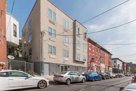 an apartment building on a city street with parked cars
