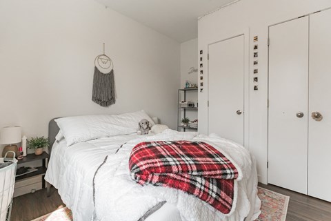 a bedroom with a white bed and a red blanket