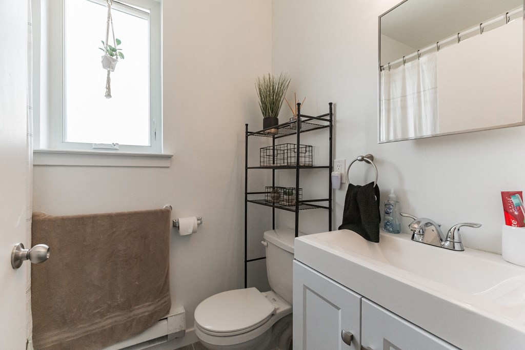 a bathroom with a toilet and a sink and a window