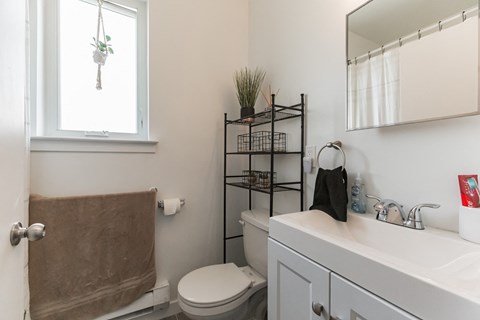 a bathroom with a toilet and a sink and a window