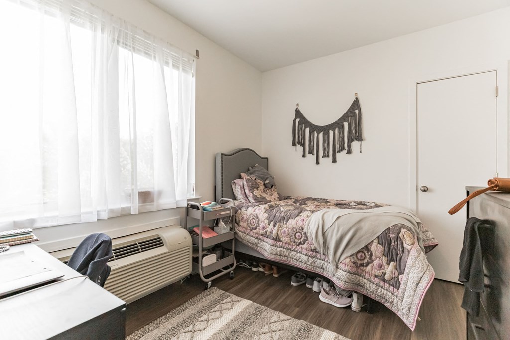 a bedroom with a bed and a dresser and a window