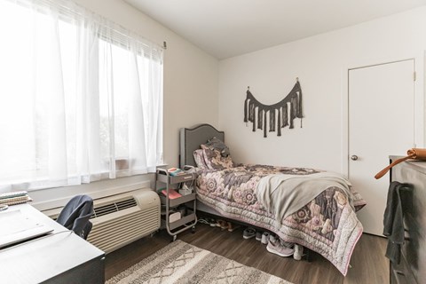 a bedroom with a bed and a dresser and a window