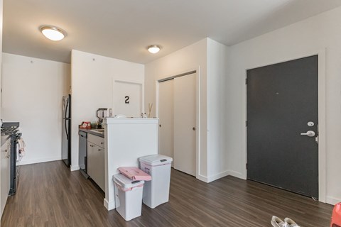 a living room with a kitchen and a black door