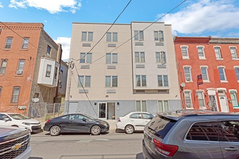 a building with a parking lot and cars on a city street