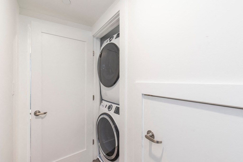 a washer and dryer in a small laundry room with a white door