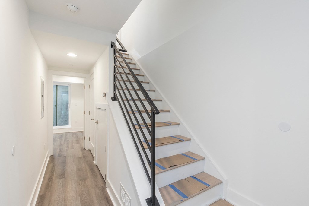 a staircase in a home with white walls and wood floors