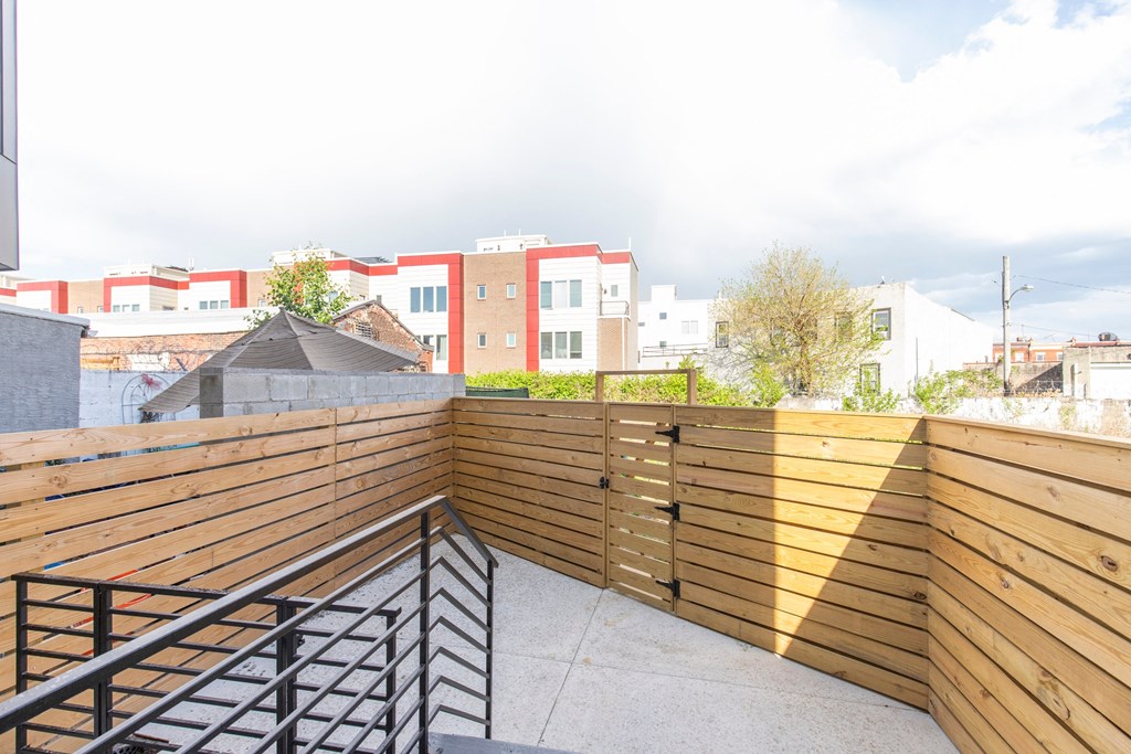 a balcony with a wooden fence and a view of some buildings