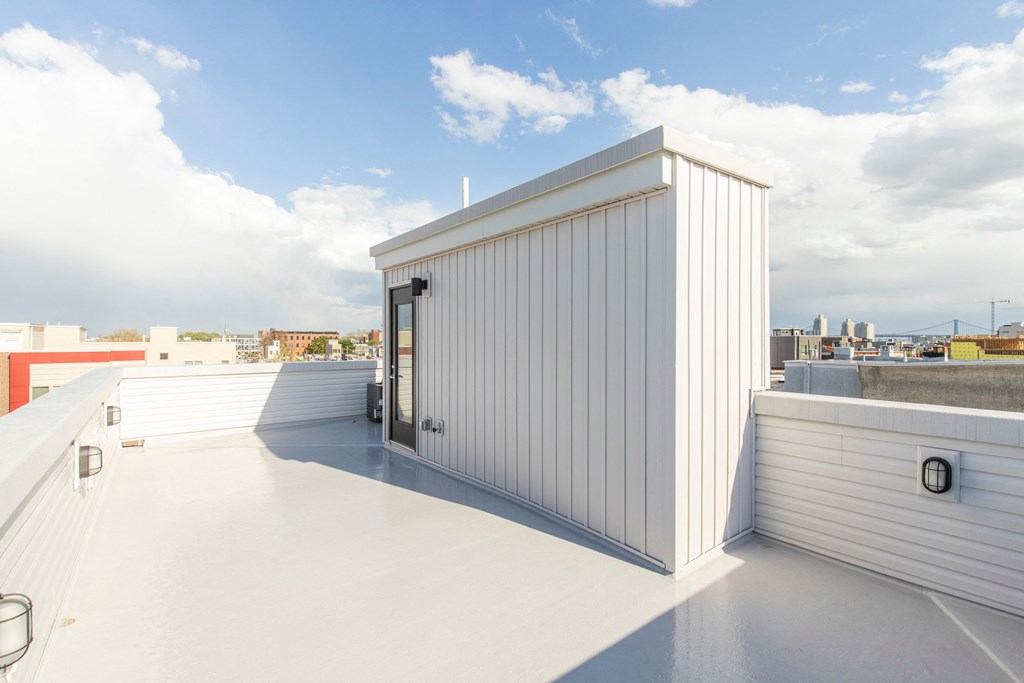 a small shed on the roof of a building with a city in the background