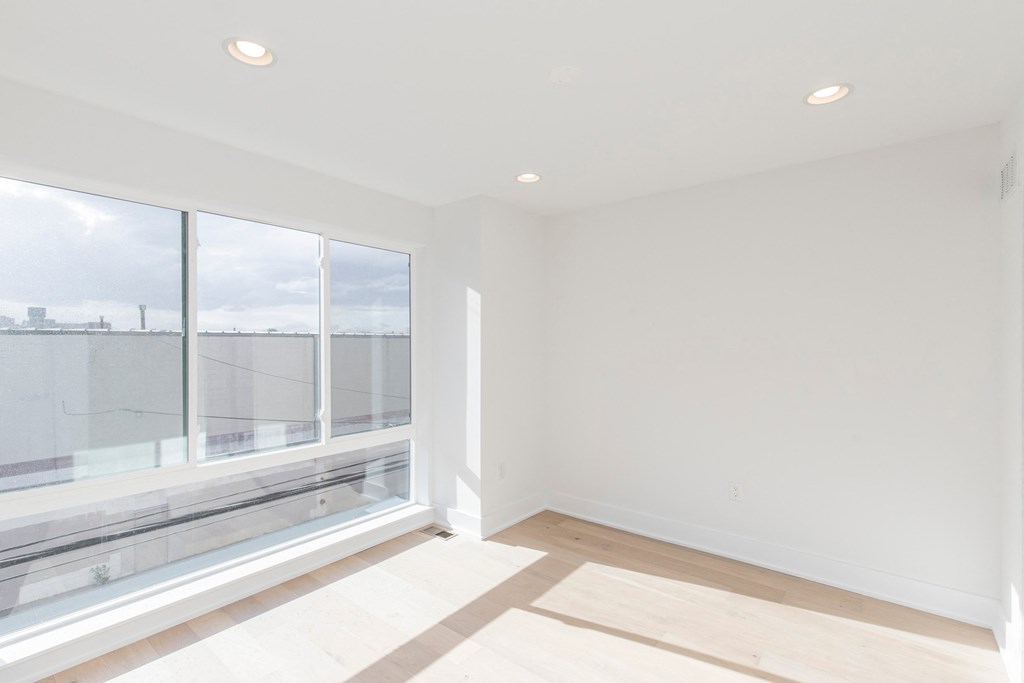 a living room with large windows and a wood floor