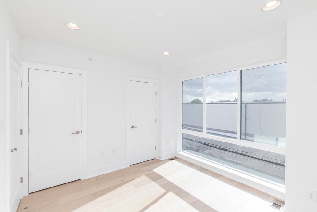 a living room with white walls and a large window