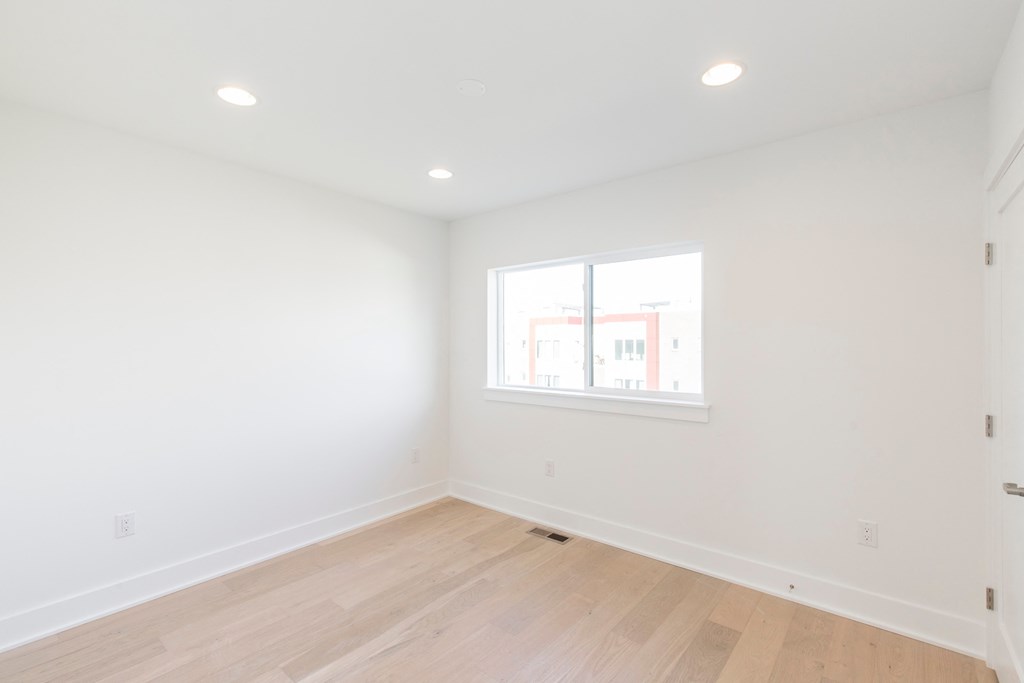 a living room with white walls and a window