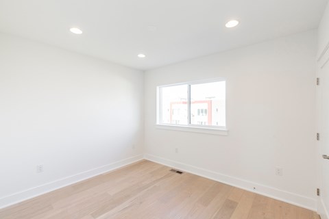 a living room with white walls and a window
