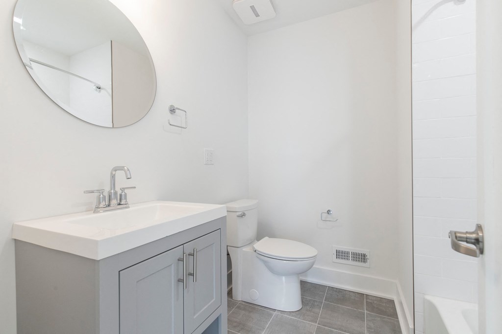 a bathroom with a toilet and a sink and a mirror