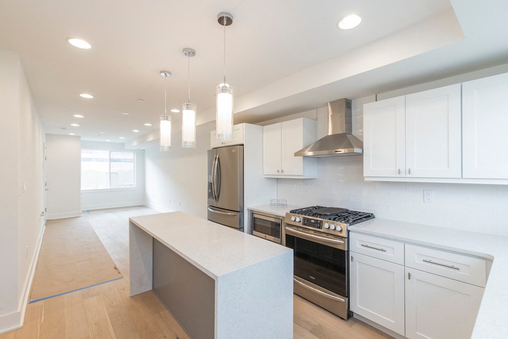 a white kitchen with white cabinets and stainless steel appliances