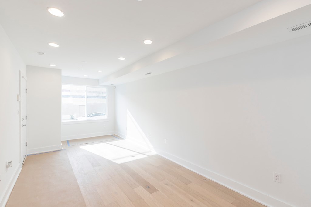 an empty room with white walls and a window