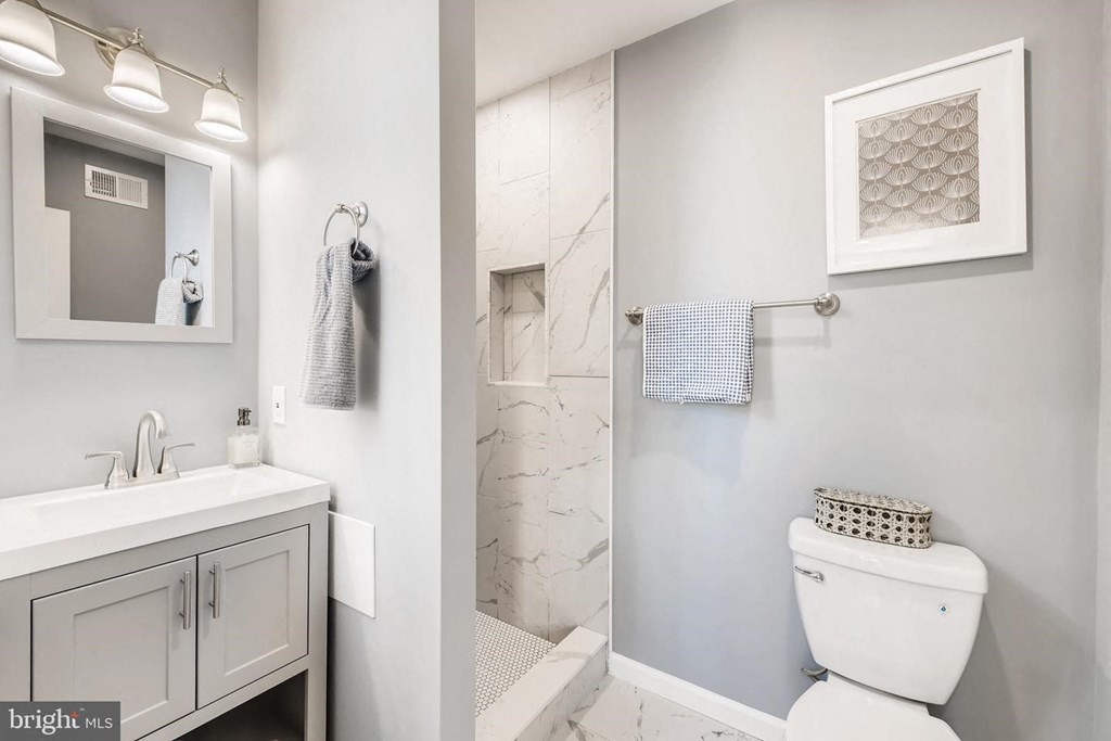 a white bathroom with a shower and a toilet