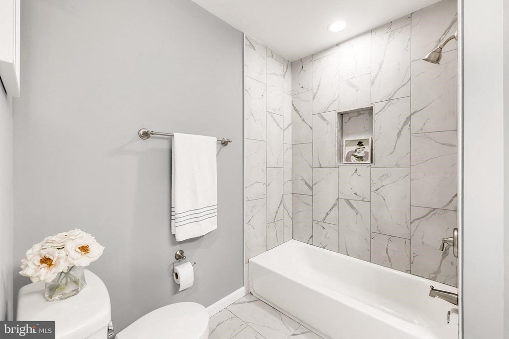 a white bathroom with a tub and a toilet