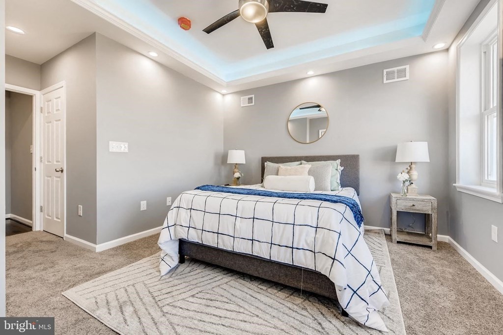 a bedroom with a bed and a ceiling fan