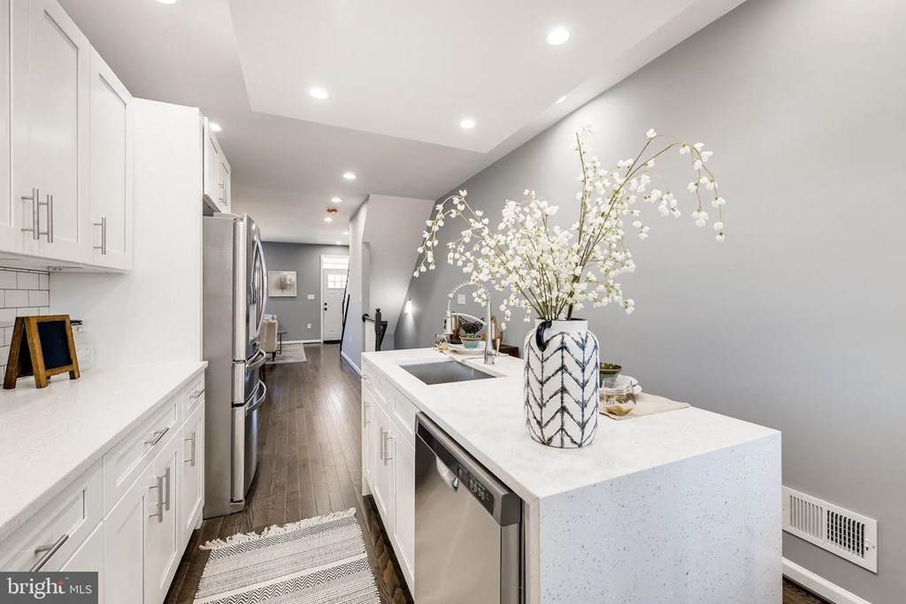 a white kitchen with a sink and a refrigerator