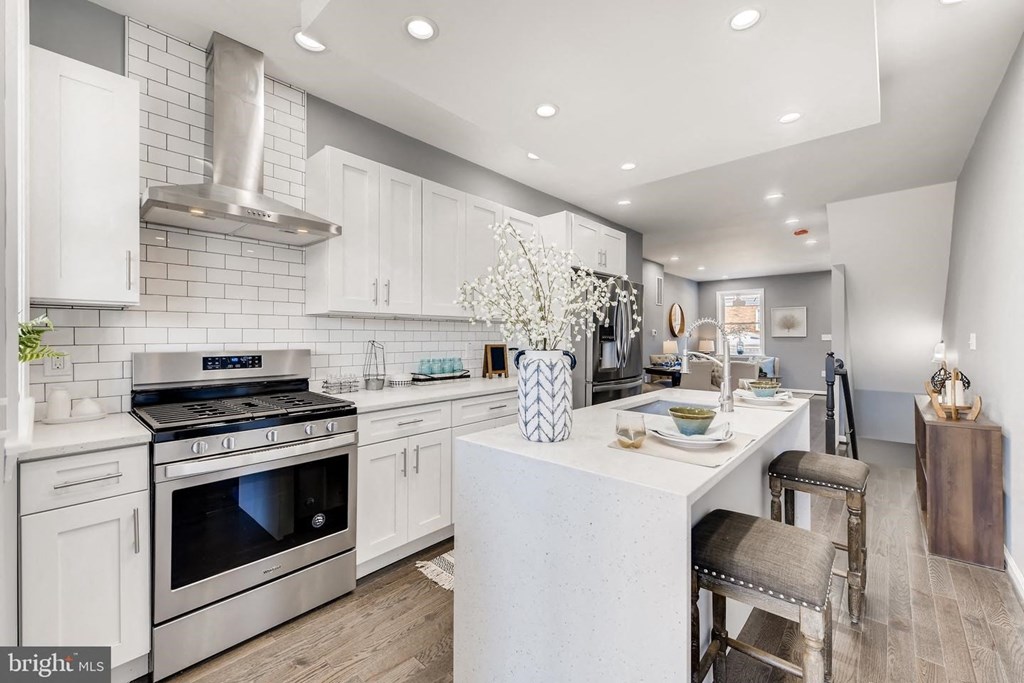 a white kitchen with a counter top and a stove