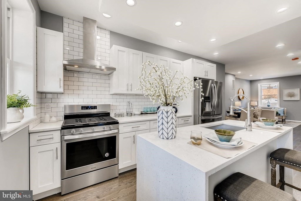 a white kitchen with a counter top and a stove