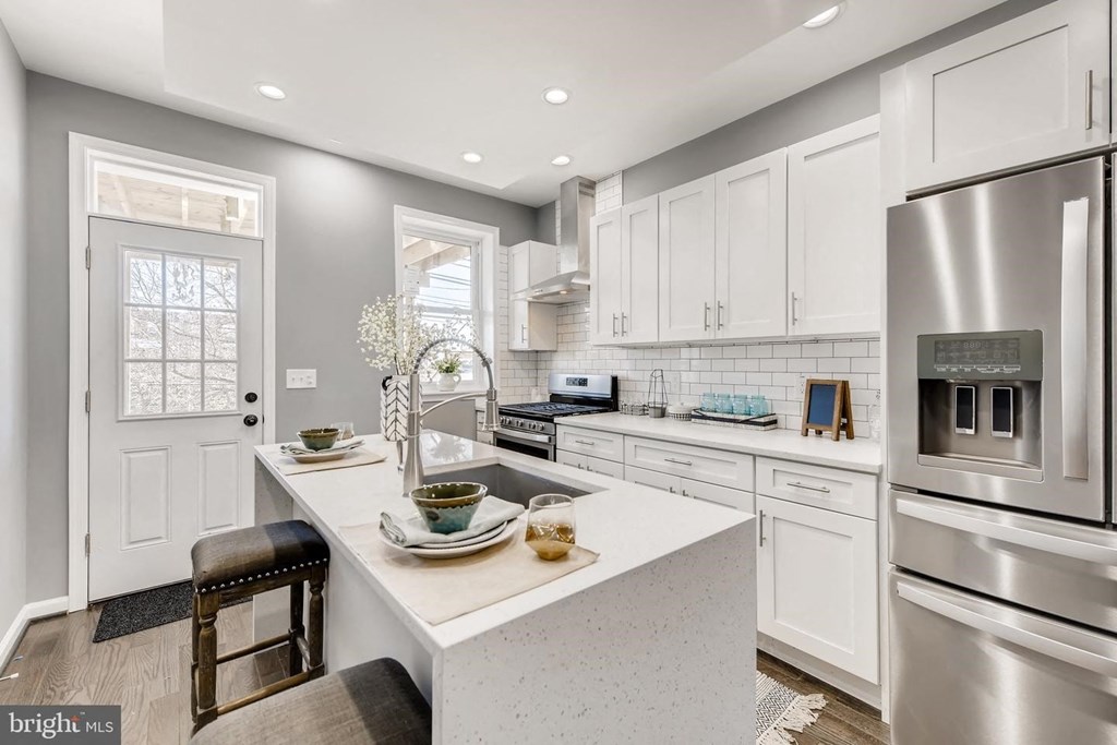 a white kitchen with stainless steel appliances