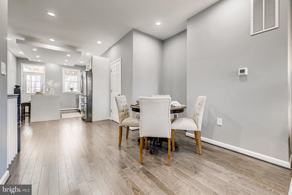a dining room with white chairs and a table