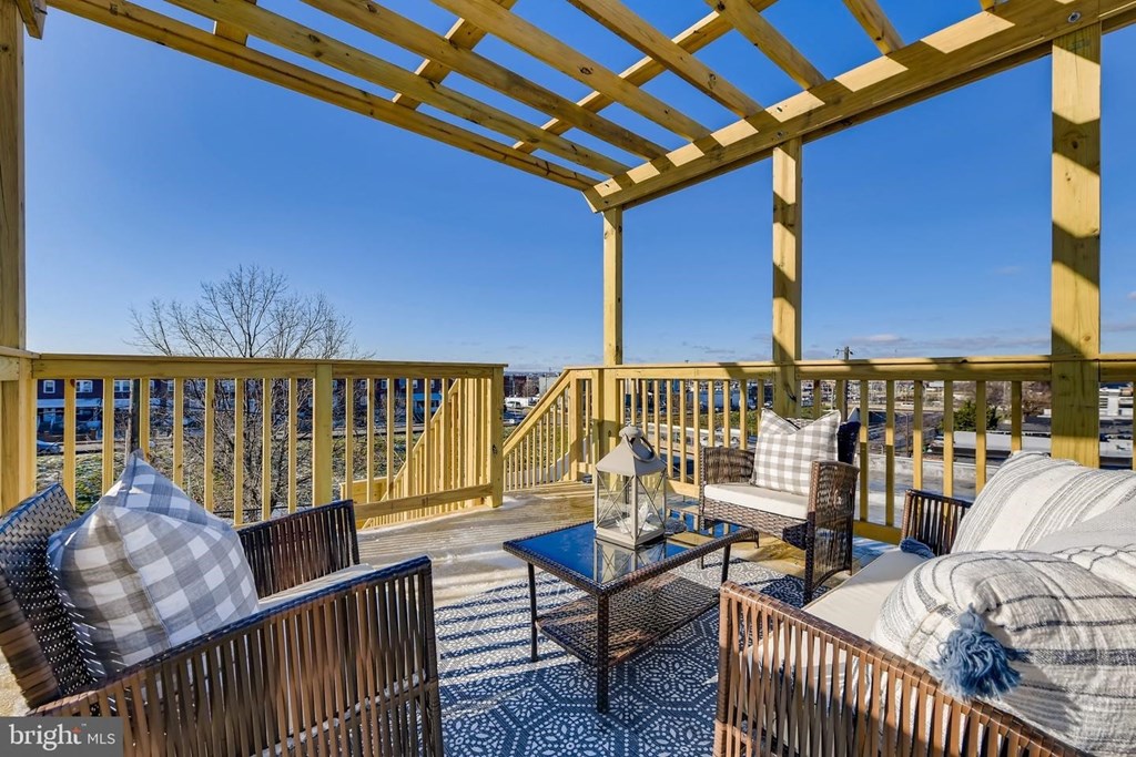 a covered deck with couches and chairs and a view