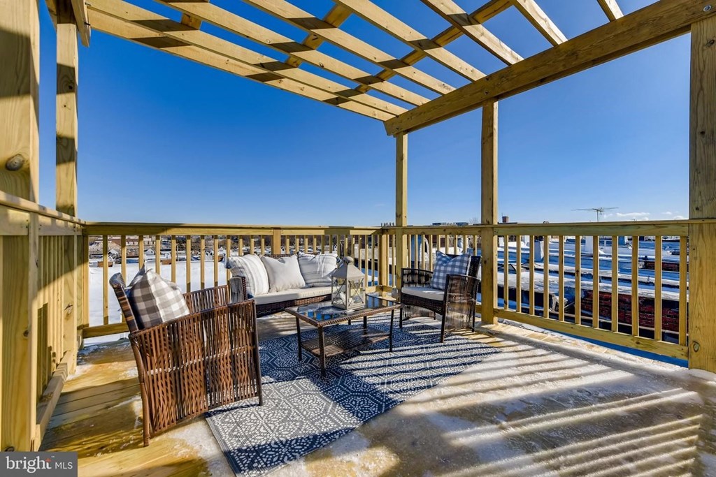 a covered deck with furniture and a view of the ocean