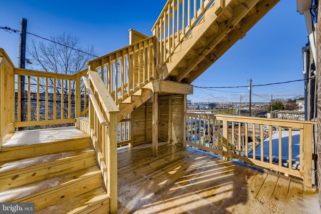 the deck of a home with wooden stairs and a view of the city