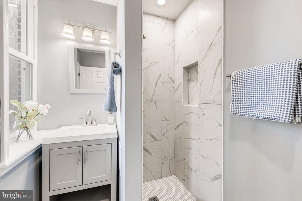 a bathroom with a shower and a sink and a mirror
