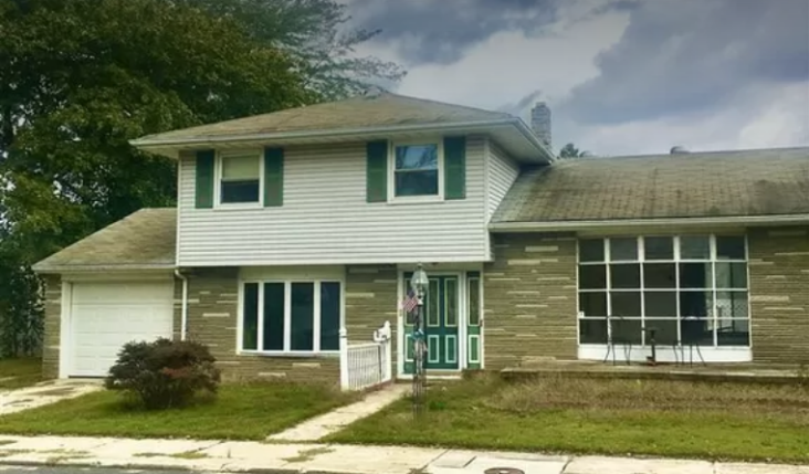 a house with green and white siding and a green door