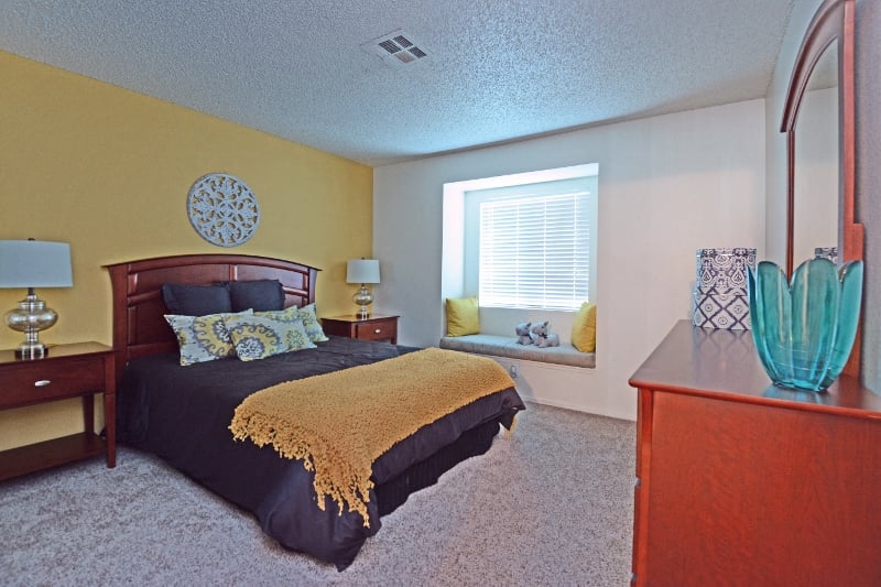 a bedroom with a bed and a dresser and a window