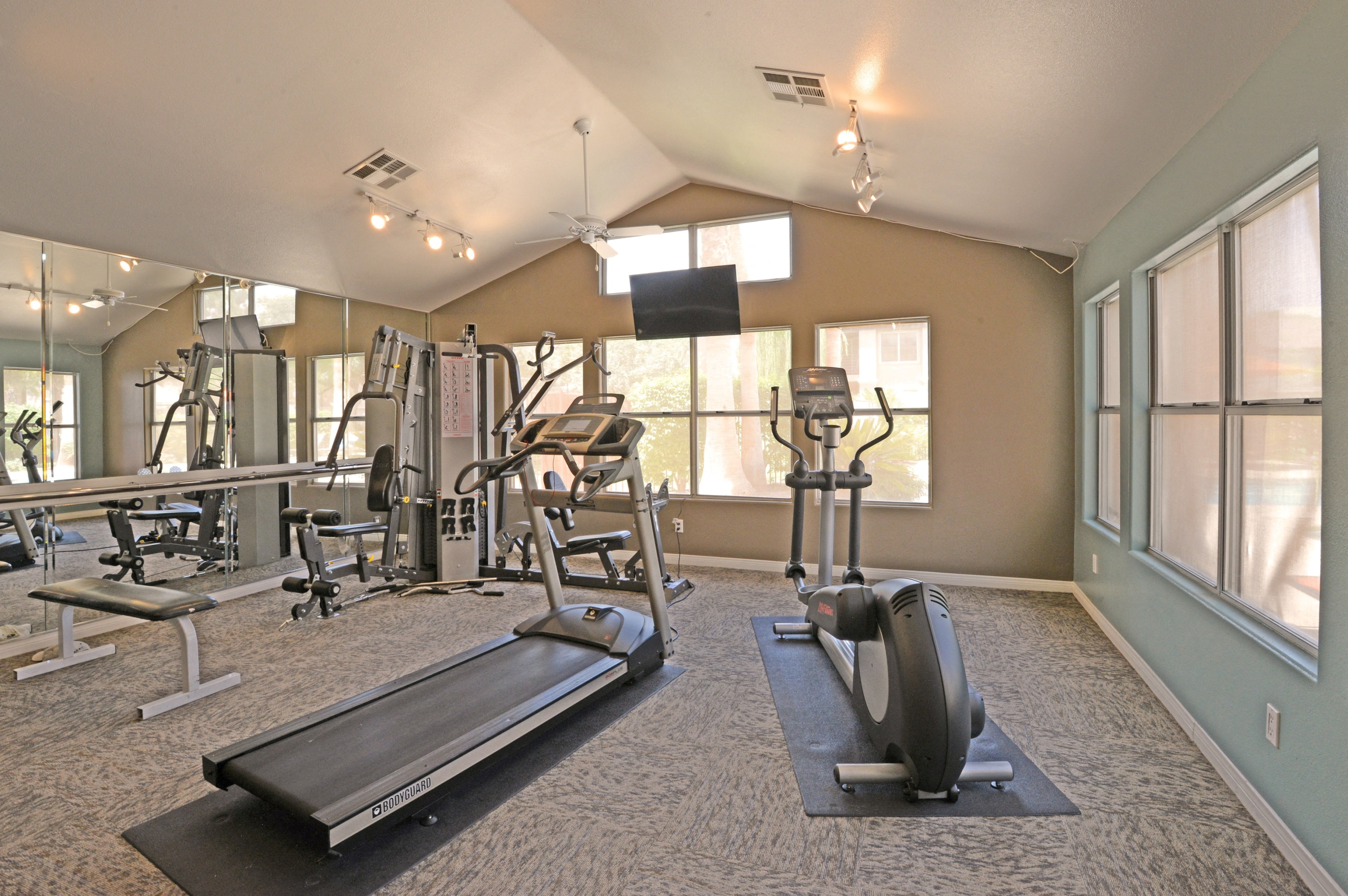 a gym with weights and cardio equipment at the estates apartments