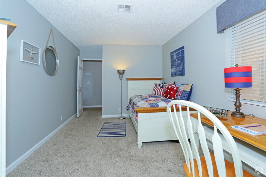 a bedroom with a bed and a desk and a chair