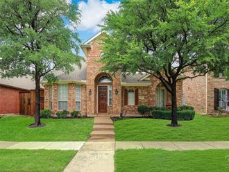 a house with a sidewalk and trees in front of it