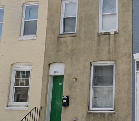 the front of a building with a green door and windows