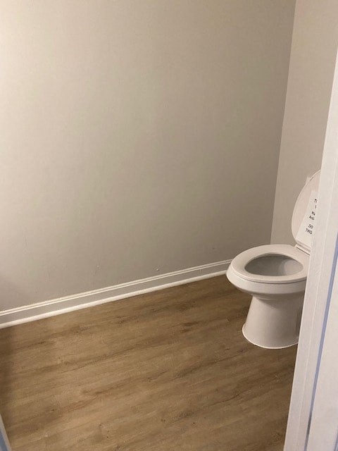 a bathroom with a toilet and a white wall
