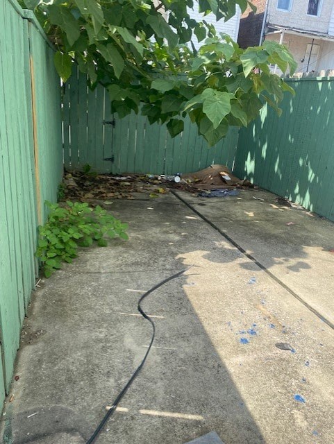 a backyard with a green fence and a tree