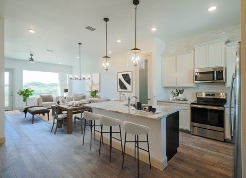 an open kitchen and dining room with a marble counter top
