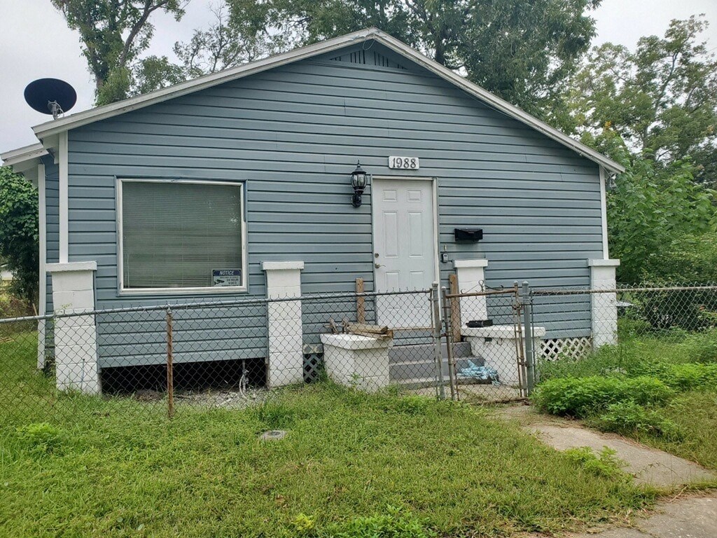 a blue house with a fence and a white door