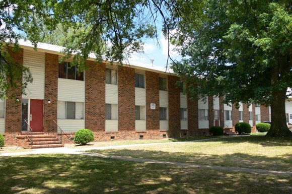 a brick building with trees in front of it