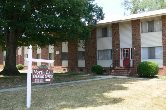 an apartment building with a north oak leasing office sign