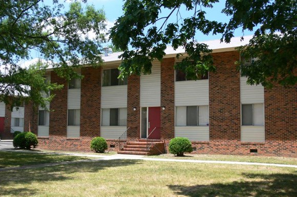 a brick and white building with a red door
