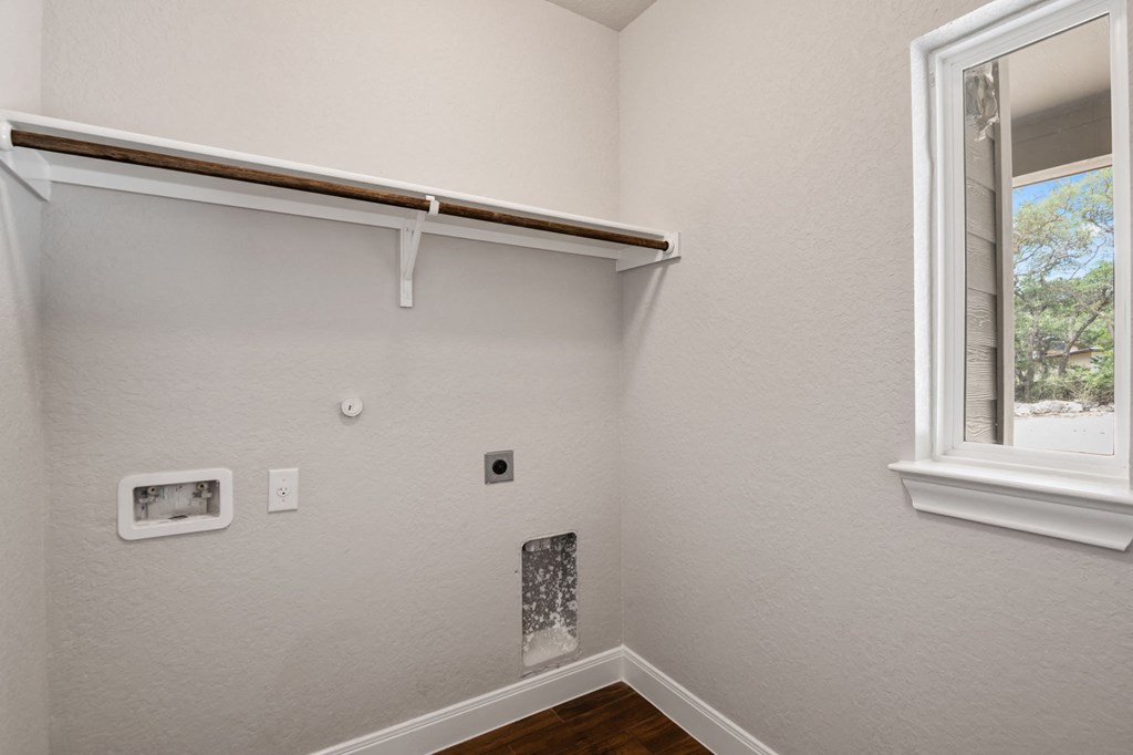 the bedroom of a house with a window and white walls