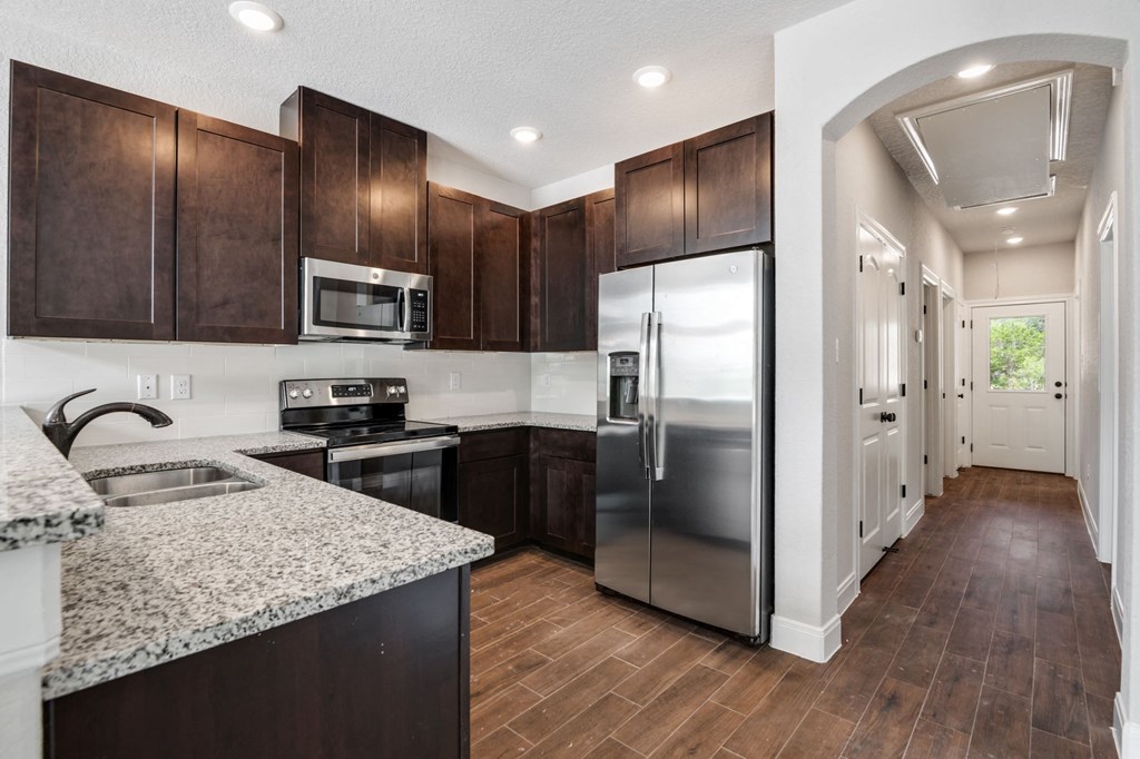 a kitchen with stainless steel appliances and marble counter tops