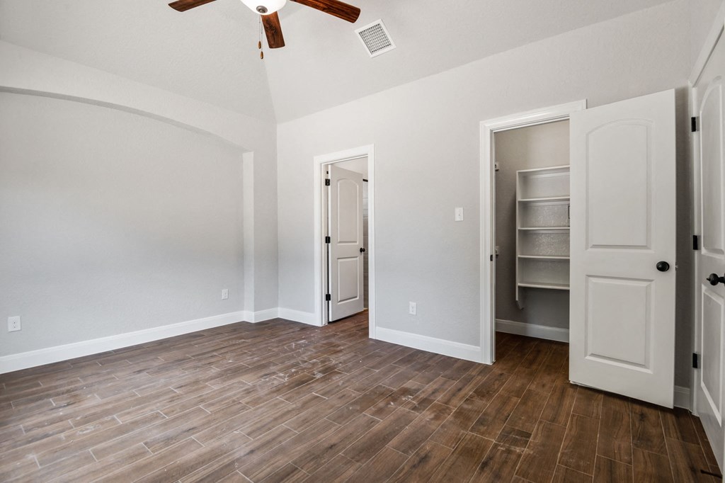 an empty living room with wood flooring and a closet