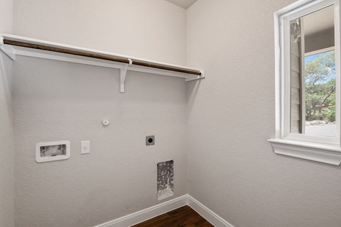 the bedroom of a house with a window and white walls