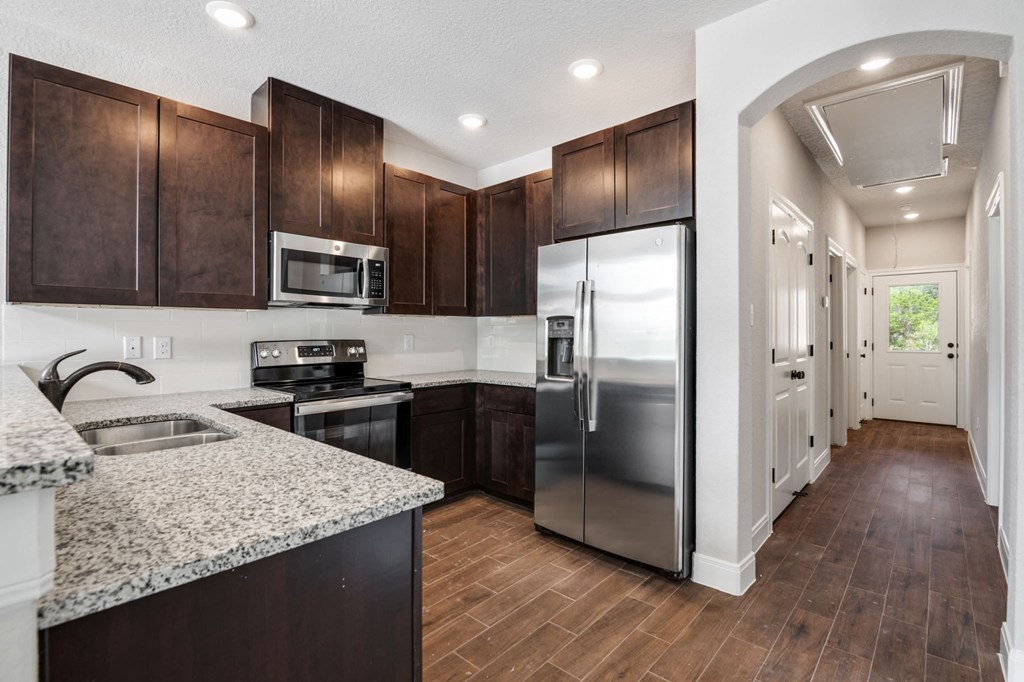 a kitchen with stainless steel appliances and marble counter tops